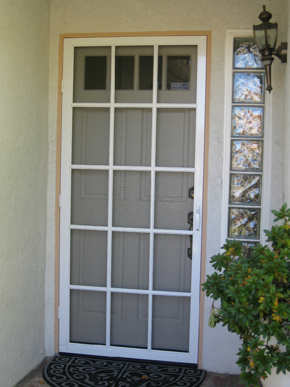 White residential swinging screen door at a home entry